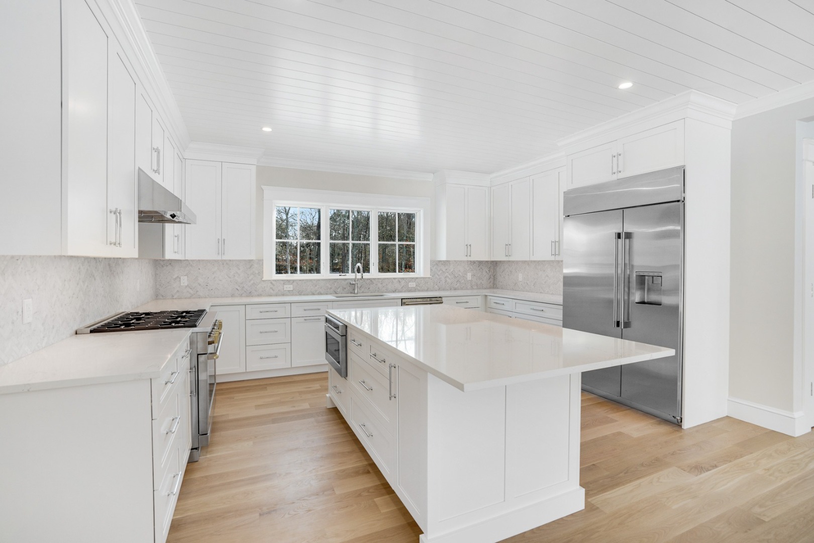 9 Martha's Way Edgartown, MA 02539 - Photo 13 of 41 a large white kitchen with stainless steel appliances granite countertop a sink and dishwasher a stove with wooden floors