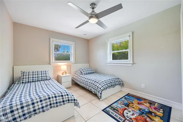a bedroom with two beds and a painting on the wall