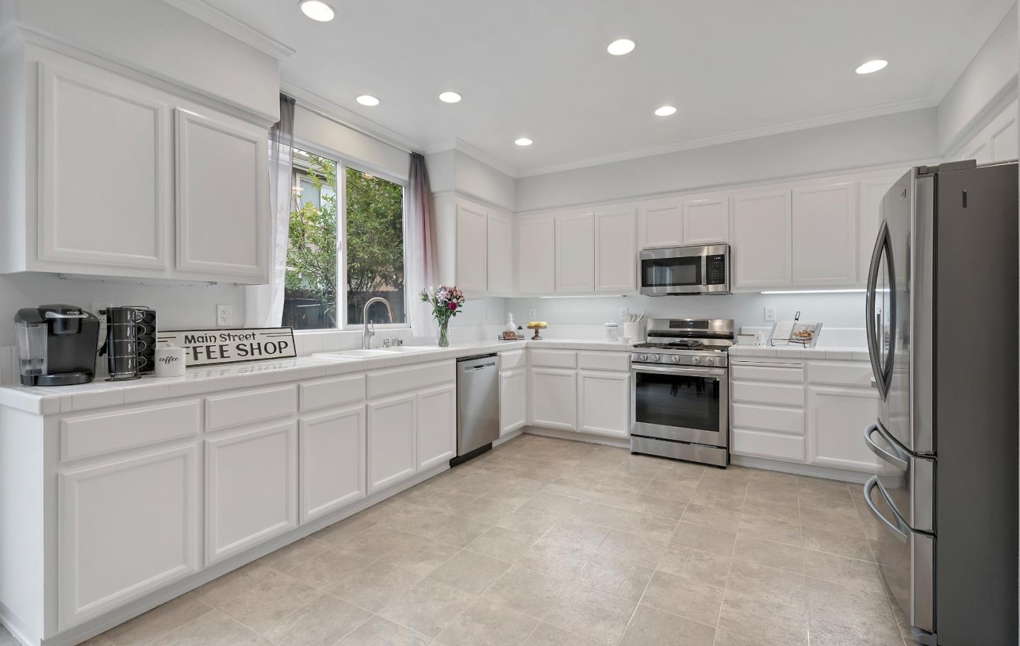 8931 Del Rio Circle Gilroy, CA 95020 - Photo 6 of 18 a kitchen with white cabinets and stainless steel appliances
