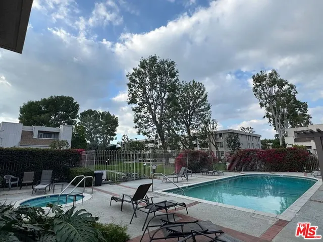 a view of a swimming pool with a patio and a yard