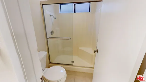 a white toilet sitting next to a shower