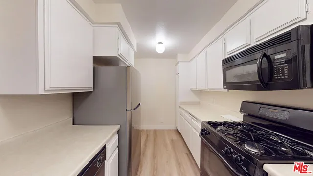a kitchen with stainless steel appliances a refrigerator and a stove top oven
