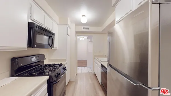 a kitchen with granite countertop a refrigerator stove and sink