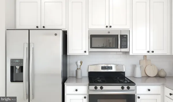 a kitchen with stainless steel appliances granite countertop a stove a refrigerator and a microwave