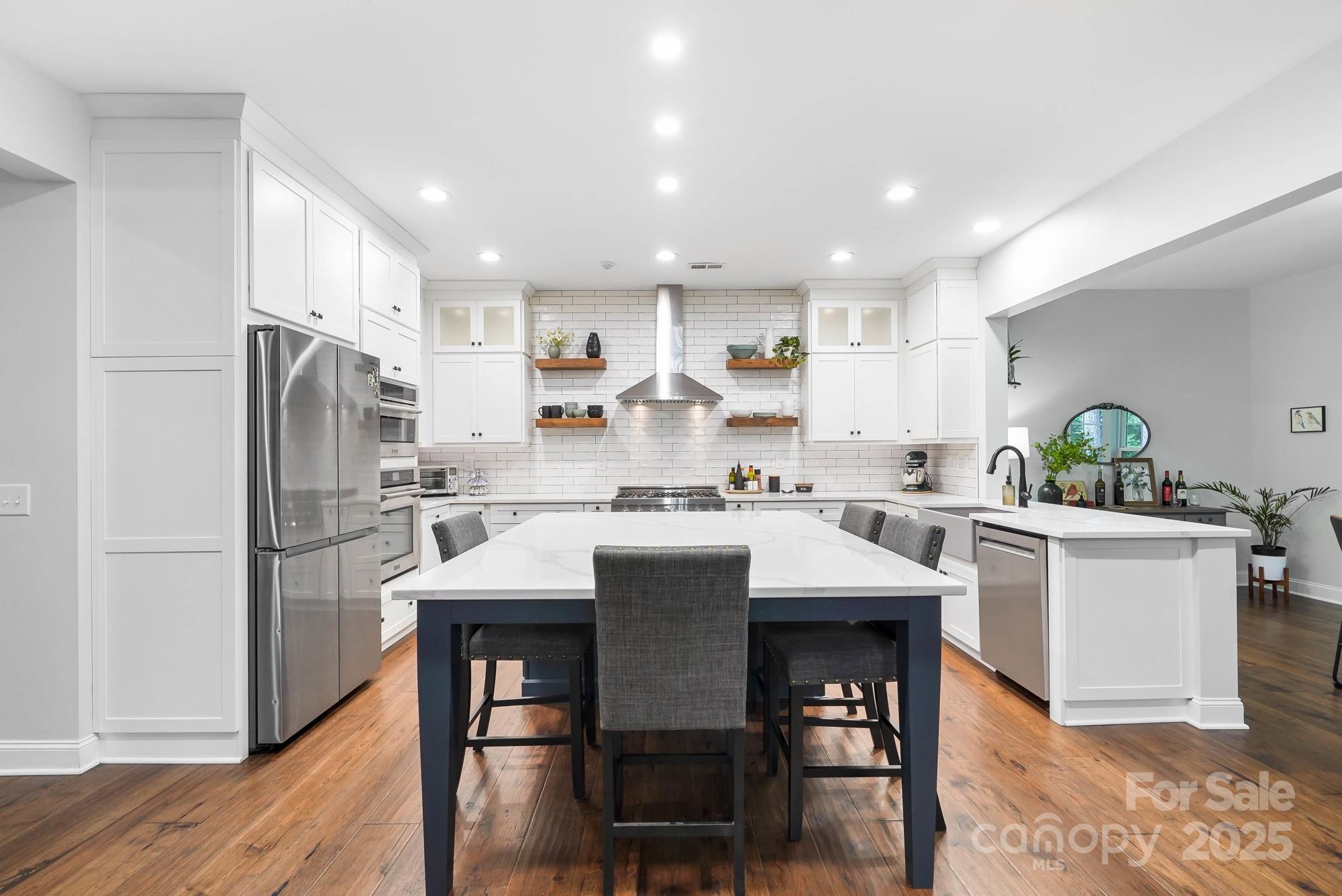 409 Stonewater Bay Mount Holly, NC 28120 - Photo 2 of 47 a kitchen with refrigerator a sink and chairs