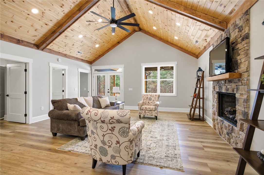 147 McAlister Road West Union, SC 29696 - Photo 6 of 49 This inviting living area boasts vaulted ceilings and a charming stone fireplace, creating an airy and warm atmosphere.