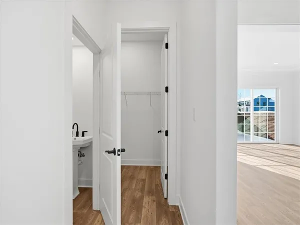 a view of a hallway with closet and wooden floor