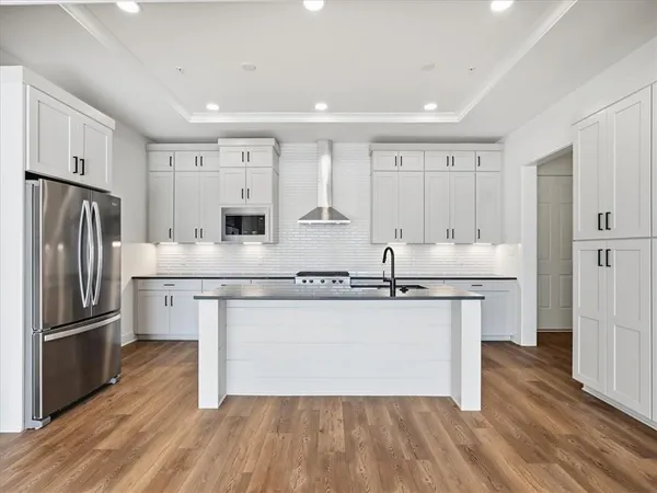 a kitchen with stainless steel appliances granite countertop a refrigerator a sink and a stove