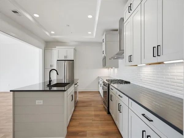 a kitchen with stainless steel appliances granite countertop a sink a stove and a refrigerator