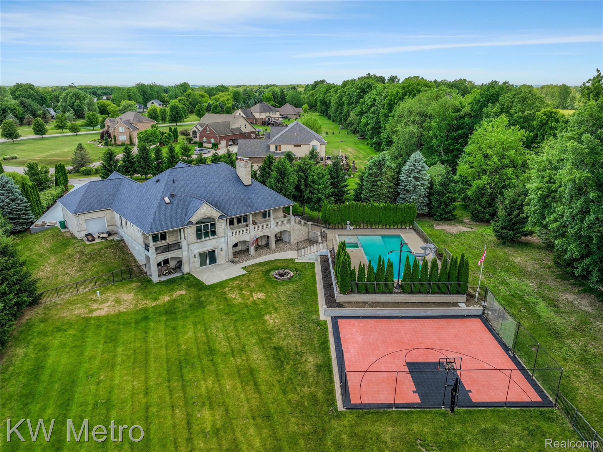 65884 Windrose Court Ray, MI 48096 - Photo 22 of 82 Expansive backyard featuring a full basketball court, a rectangular in-ground pool, and a stone patio
