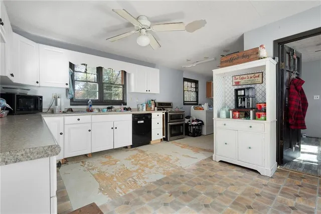a kitchen with cabinets stainless steel appliances and a window