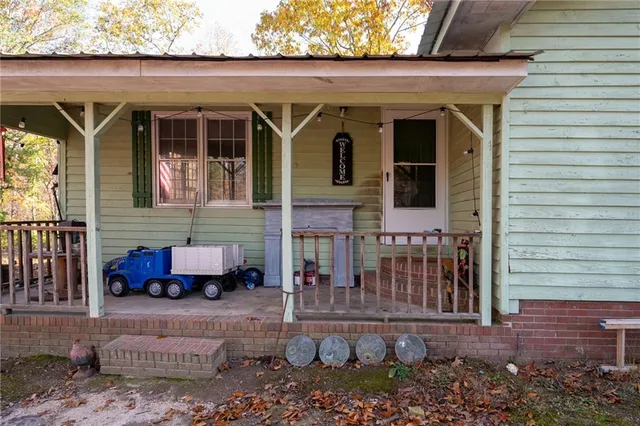 a view of a brick house with potted plants and a table and chairs