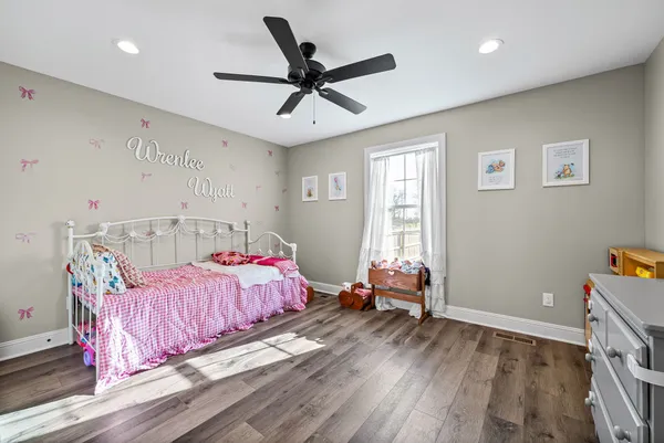 a bedroom with a bed and wooden floor