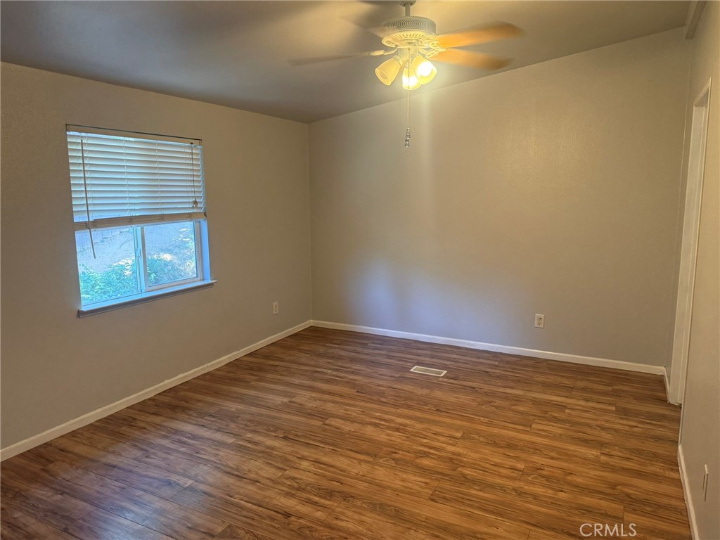 6845 Floyd Way Nice, CA 95464 - Photo 23 of 59 a view of an empty room with wooden floor and a window