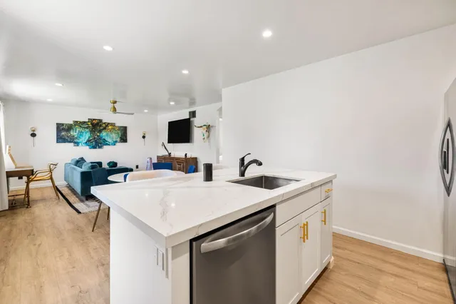 a kitchen with a sink a counter top space and stainless steel appliances