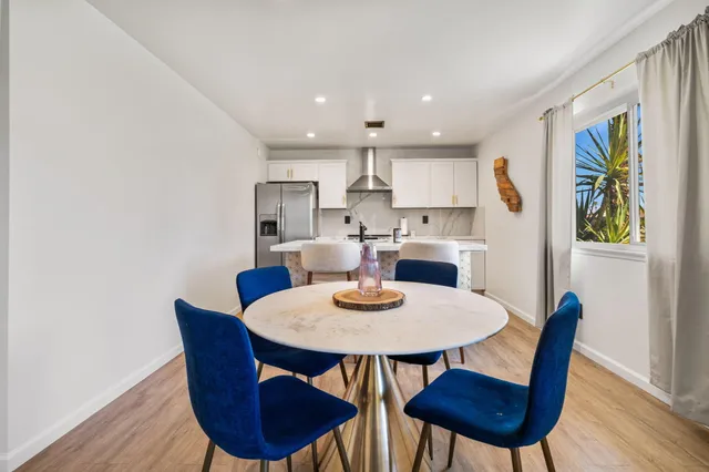 a view of a dining room with furniture a rug and wooden floor