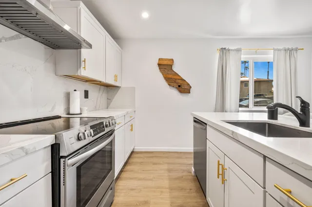 a kitchen with stainless steel appliances granite countertop a sink and a stove