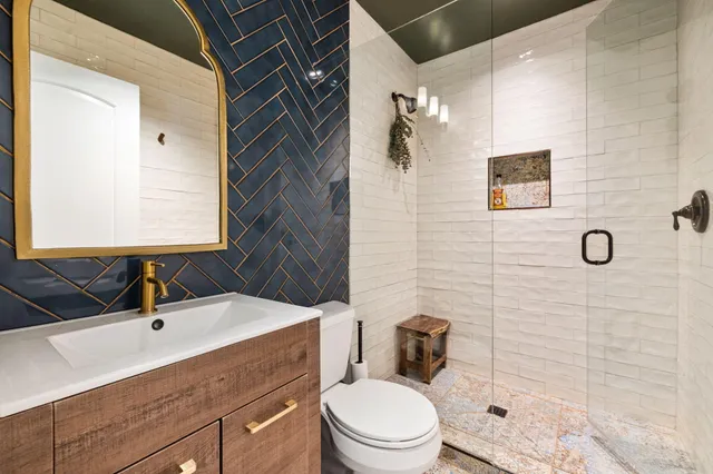 a bathroom with a sink toilet vanity and shower
