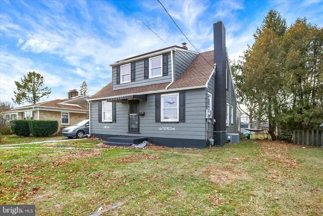 a view of a house with a big yard and large tree