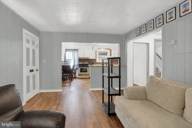 a living room with stainless steel appliances furniture and a kitchen view