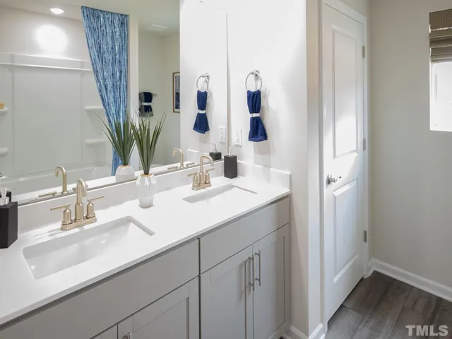 a bathroom with double vanity sink and mirror
