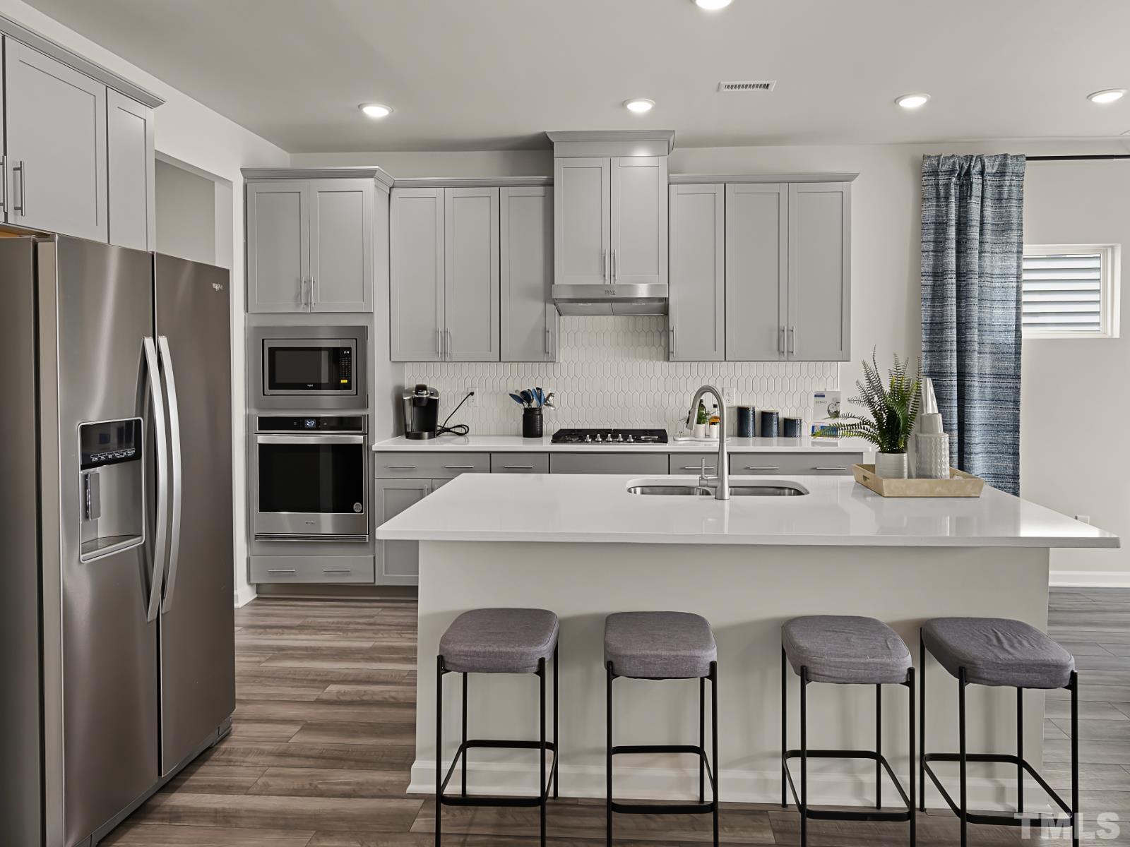 3013 Farndale Trace Durham, NC 27712 - Photo 3 of 14 a kitchen with stainless steel appliances granite countertop a table chairs refrigerator and microwave