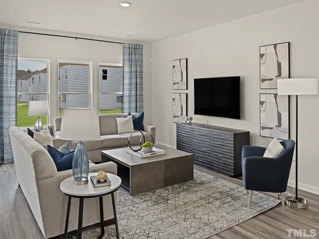 a living room with furniture a flat screen tv and a large window