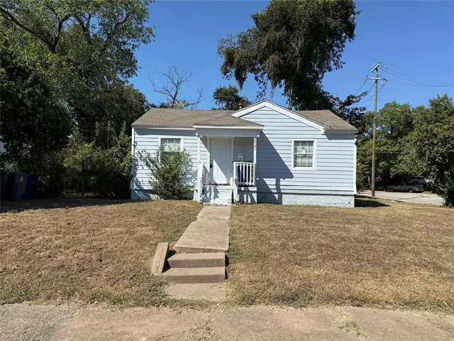 a view of a house with backyard and trees