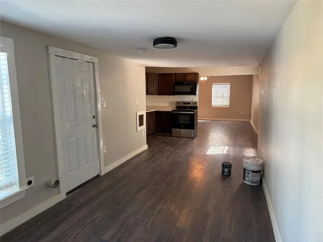 wooden floor in kitchen and empty room with window