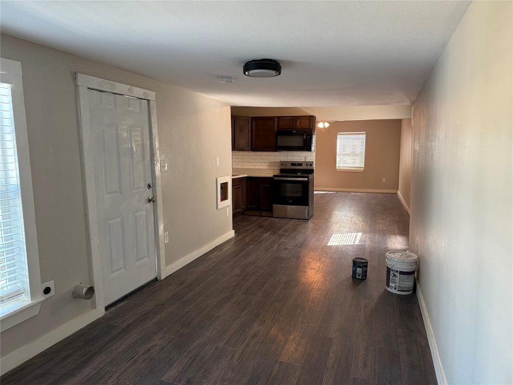 2781 Locust Avenue Dallas, TX 75216 - Photo 11 of 15 wooden floor in kitchen and empty room with window
