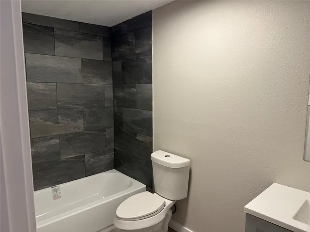 a white toilet sitting next to a bathtub