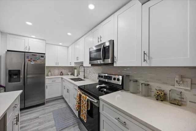 a kitchen with stainless steel appliances a refrigerator sink and microwave
