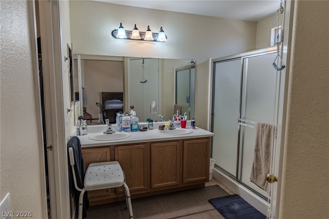 4994 Mascaro Drive Las Vegas, NV 89122 - Photo 12 of 30 Double vanity and a glass-enclosed shower create a functional and efficient bathroom space.
