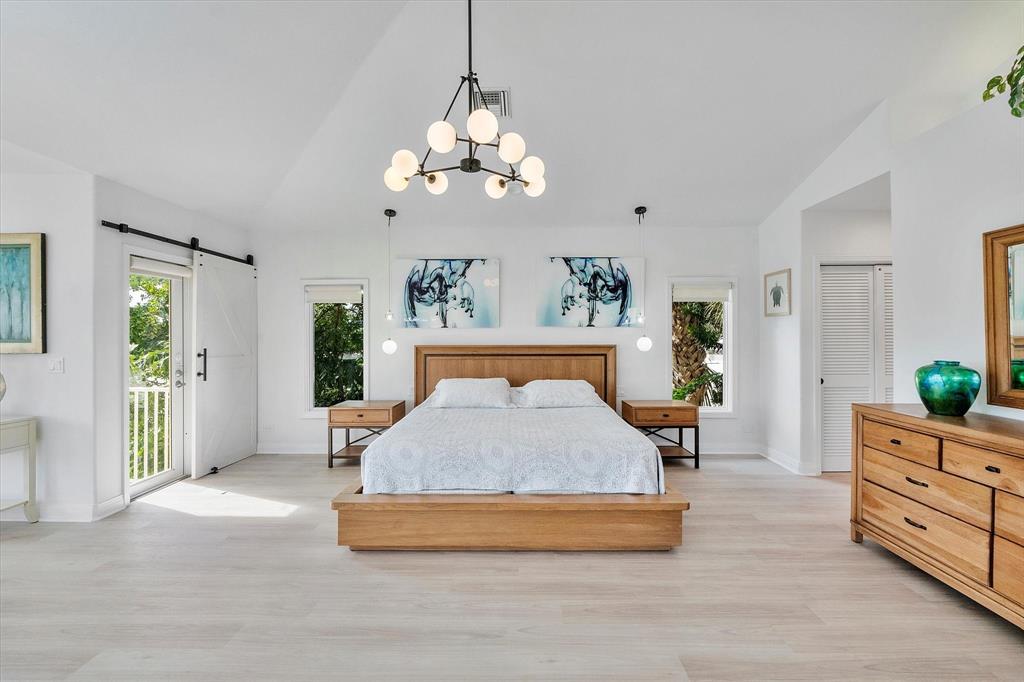 2484 Southeast 12th Street Pompano Beach, FL 33062 - Photo 22 of 61 a bedroom with a large bed and a chandelier