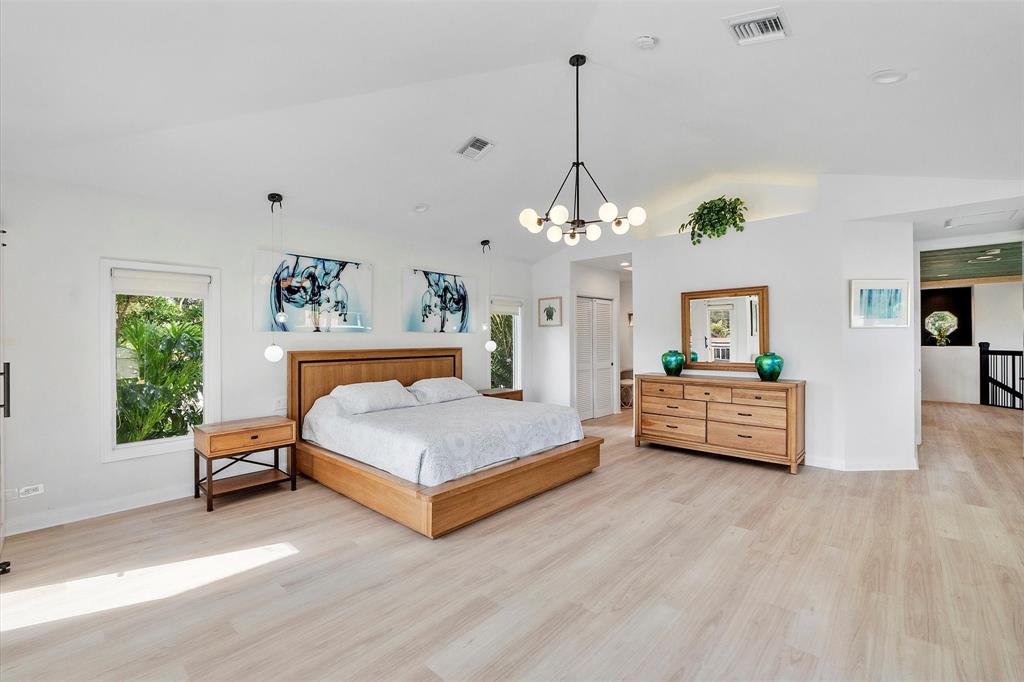 2484 Southeast 12th Street Pompano Beach, FL 33062 - Photo 23 of 61 a spacious bedroom with a bed chandelier and window