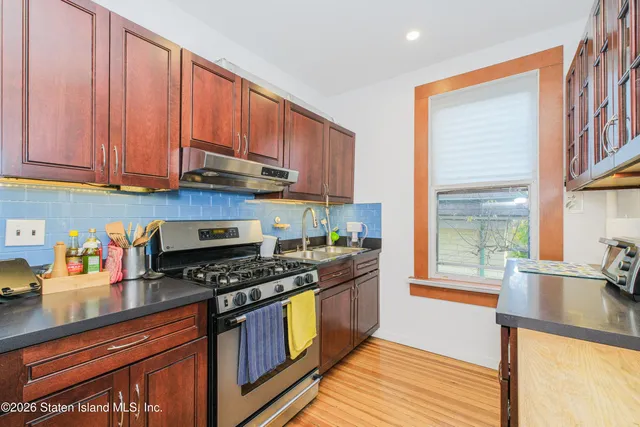 a kitchen with wooden cabinets stainless steel appliances and a sink