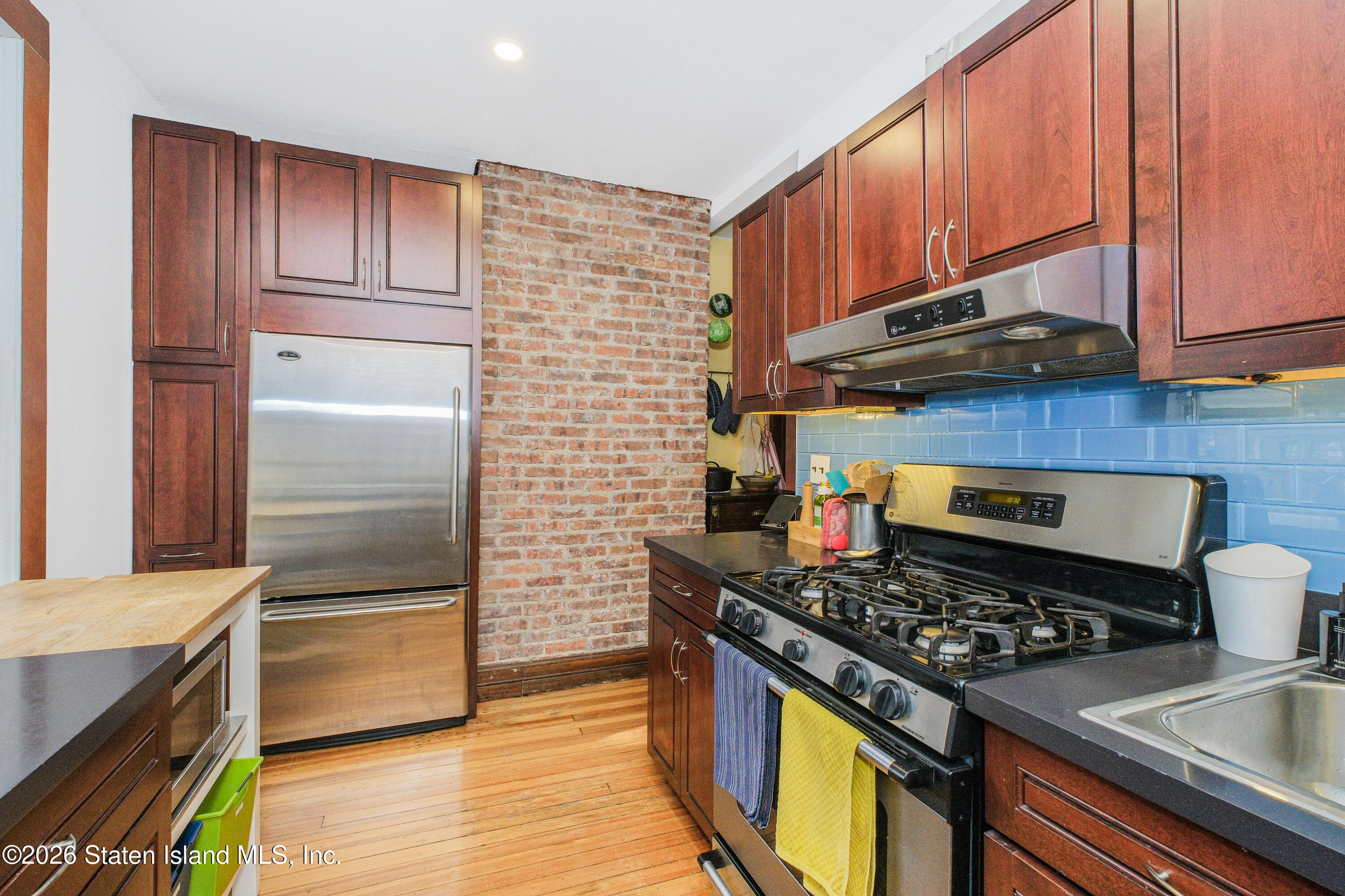 98 Hamilton Avenue Staten Island, NY 10301 - Photo 35 of 55 a kitchen with wooden cabinets stainless steel appliances and a sink