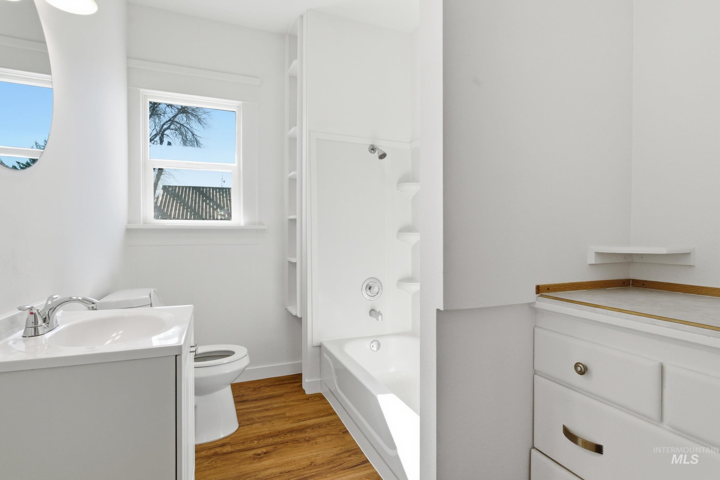 107 West Main Street Declo, ID 83323 - Photo 13 of 32 Bathroom featuring vanity, light wood-style flooring, and bathing tub / shower combination