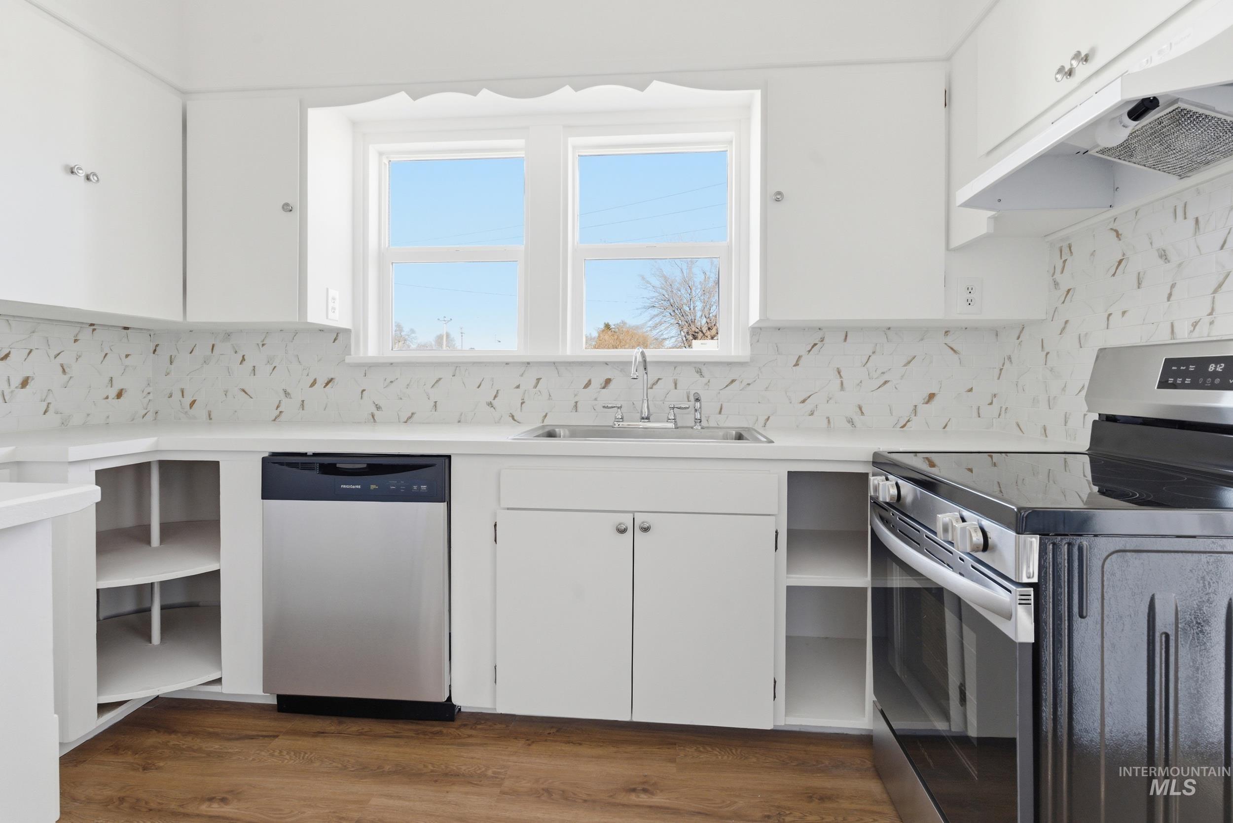 107 West Main Street Declo, ID 83323 - Photo 5 of 32 Kitchen with stainless steel appliances, white cabinetry, light countertops, and dark wood-style floors