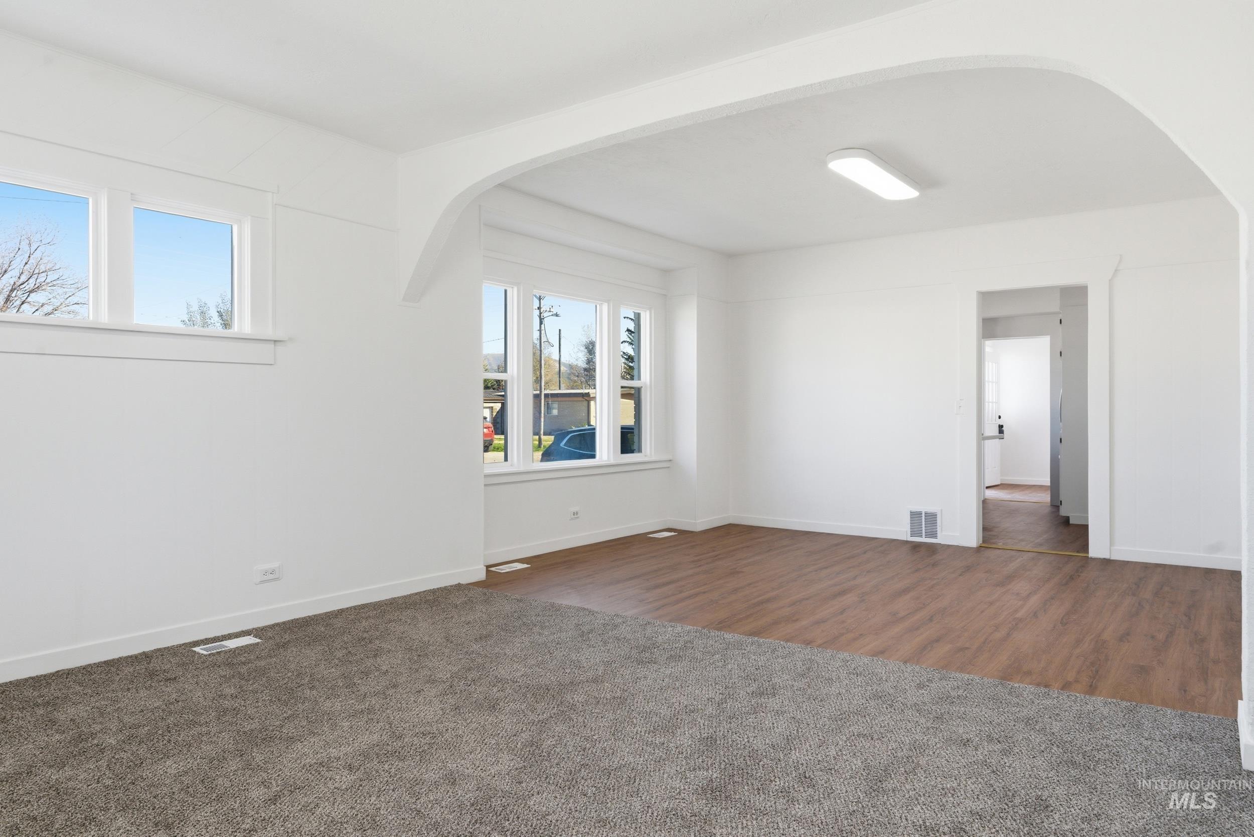 107 West Main Street Declo, ID 83323 - Photo 8 of 32 Unfurnished room featuring arched walkways and dark colored carpet