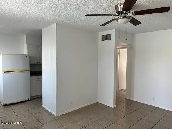 a view of a refrigerator in kitchen and white cabinets
