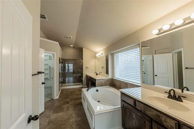 a bathroom with a granite countertop sink a mirror and shower