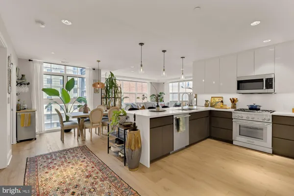 a open kitchen with stainless steel appliances granite countertop a stove top oven a sink a dining table and chairs