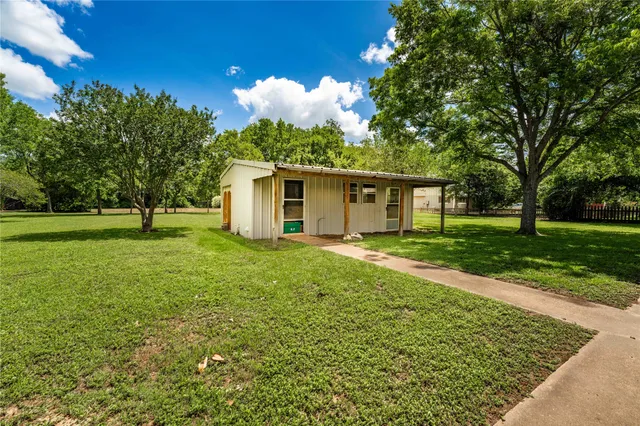 a view of a house with backyard and a tree