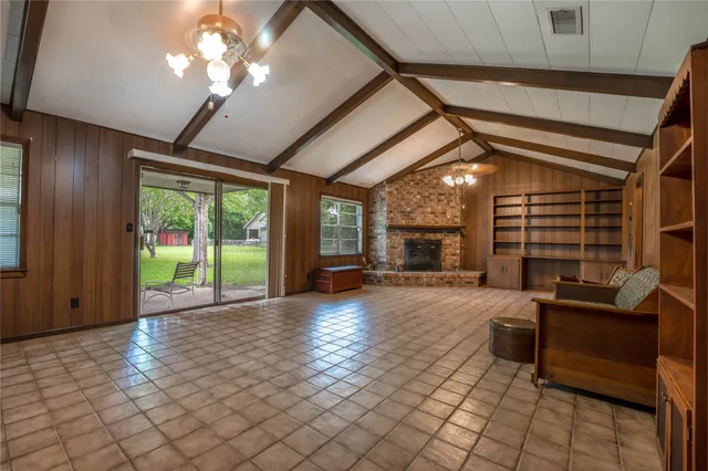 a view of a livingroom with furniture chandelier and windows
