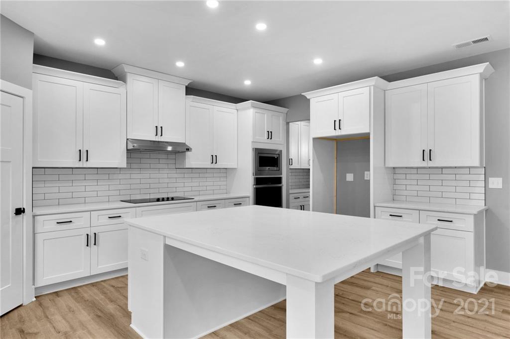 13500 Old Camden Road Midland, NC 28107 - Photo 17 of 41 a kitchen with a refrigerator a sink and white cabinets