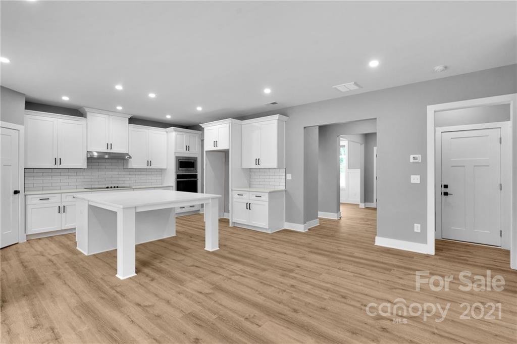 13500 Old Camden Road Midland, NC 28107 - Photo 23 of 41 a large kitchen with a center island wooden floor stainless steel appliances and cabinets