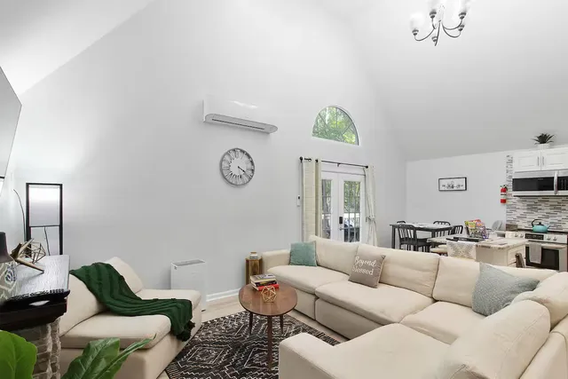 a living room with furniture kitchen view and a window