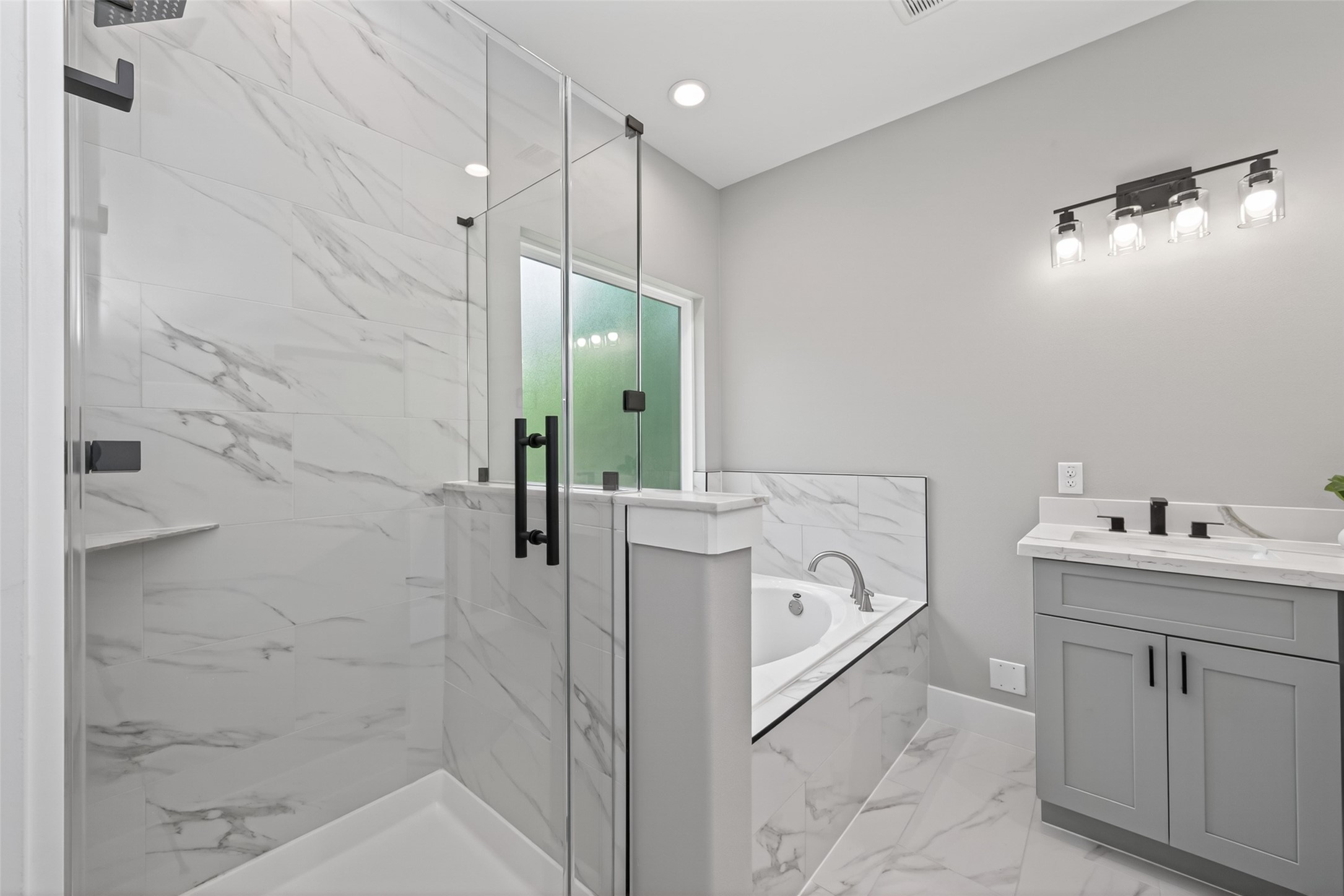 12431 Green Ridge Drive Willis, TX 77318 - Photo 18 of 37 Modern, spa-like primary bathroom with high-end finishes and a clean, elegant design. Black round mirrors are being installed.