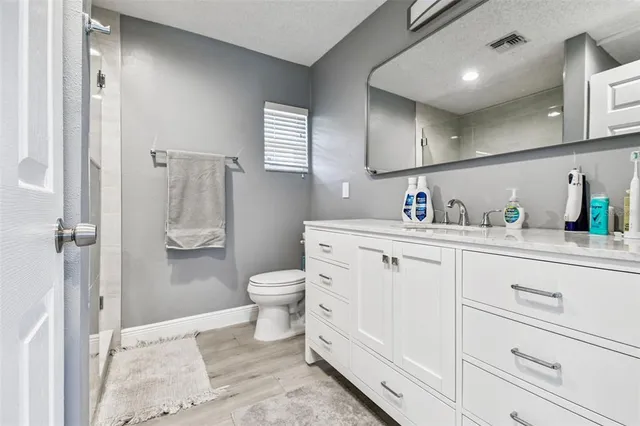 a bathroom with a sink a toilet and shower